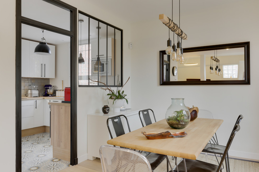 Medium sized urban open plan dining room in Paris with white walls, light hardwood flooring and beige floors.