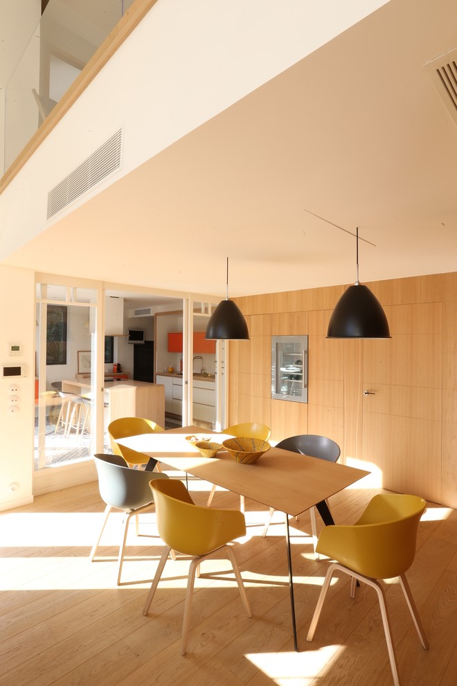 Cette photo montre une salle à manger tendance de taille moyenne et fermée avec un sol en bois brun et aucune cheminée.
