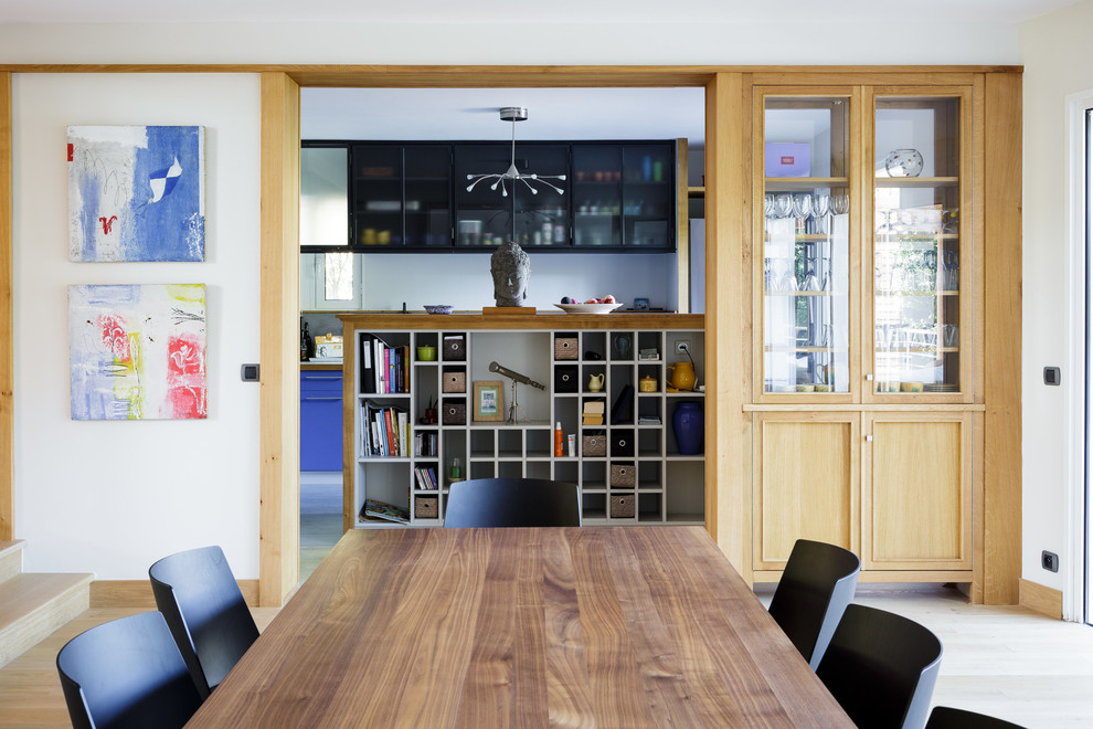 Idee per una sala da pranzo aperta verso il soggiorno design di medie dimensioni con pareti bianche e parquet chiaro