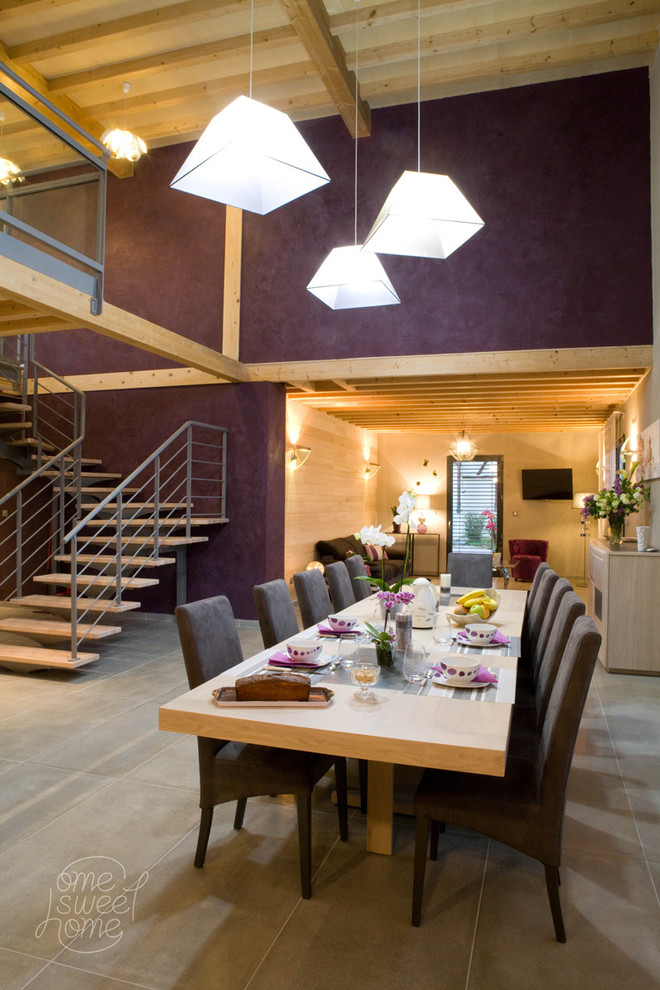 На фото: гостиная-столовая в современном стиле с фиолетовыми стенами и бетонным полом