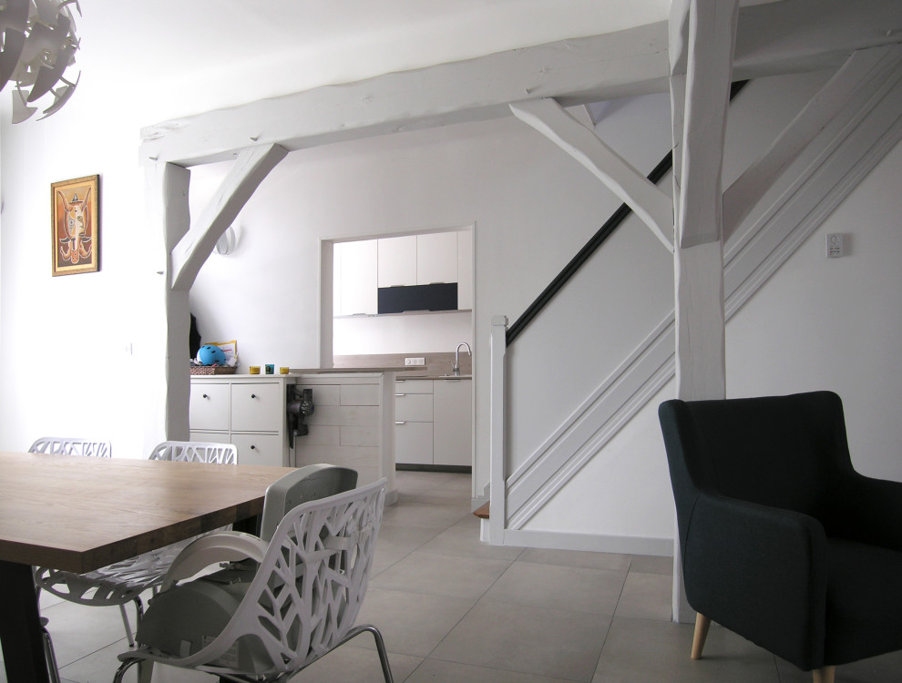 Exemple d'une salle à manger ouverte sur le salon tendance avec un mur blanc.