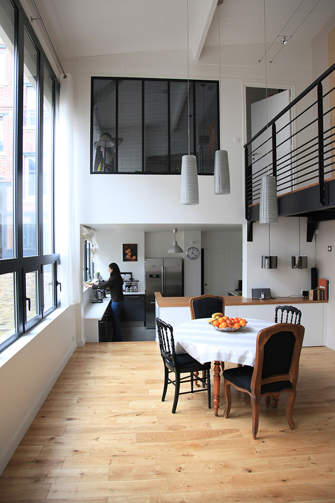 Esempio di una sala da pranzo aperta verso la cucina minimal di medie dimensioni con pareti bianche e pavimento in legno massello medio