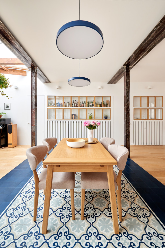 Immagine di una grande sala da pranzo aperta verso il soggiorno design con pareti bianche, pavimento in terracotta, nessun camino e pavimento blu
