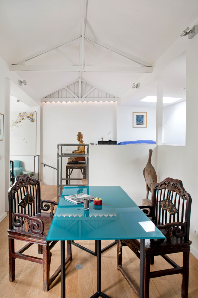 Immagine di una sala da pranzo aperta verso il soggiorno boho chic con pareti bianche, pavimento in legno massello medio, pavimento marrone e soffitto a volta