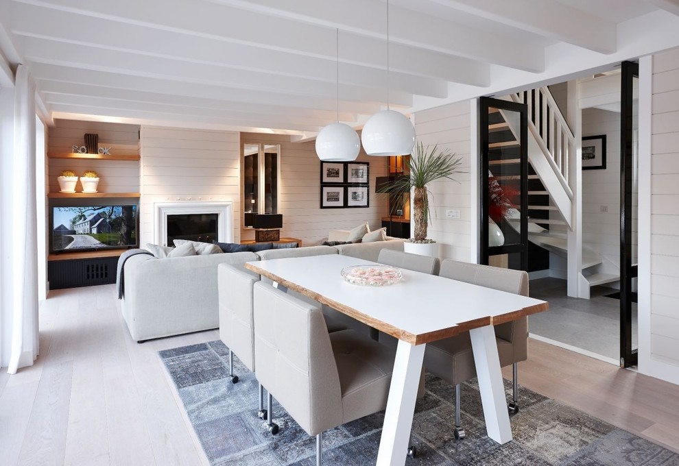 Idée de décoration pour une salle à manger ouverte sur le salon tradition de taille moyenne avec un mur gris et parquet clair.