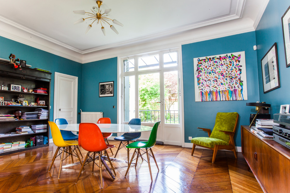 Geschlossenes, Großes Modernes Esszimmer mit blauer Wandfarbe und braunem Holzboden in Paris
