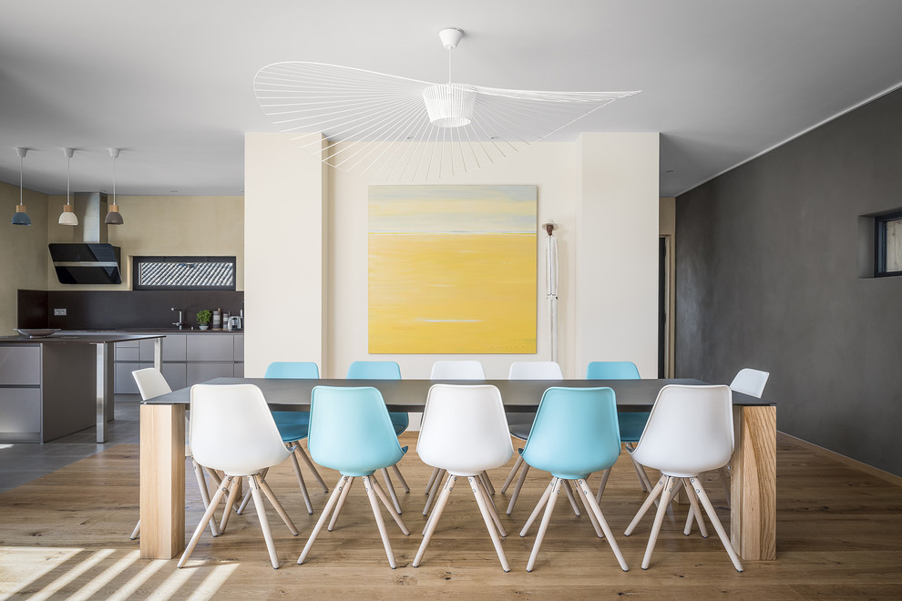 Idee per una sala da pranzo aperta verso la cucina design con pareti multicolore e parquet chiaro