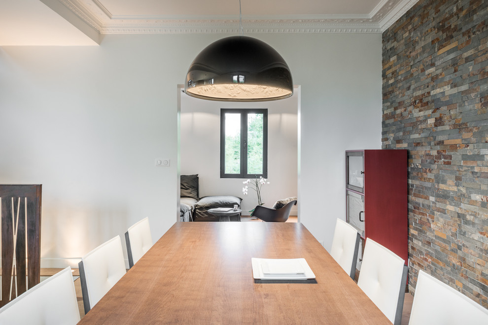 Foto di una sala da pranzo aperta verso la cucina minimal di medie dimensioni con pareti multicolore, pavimento in legno massello medio, nessun camino e pavimento marrone