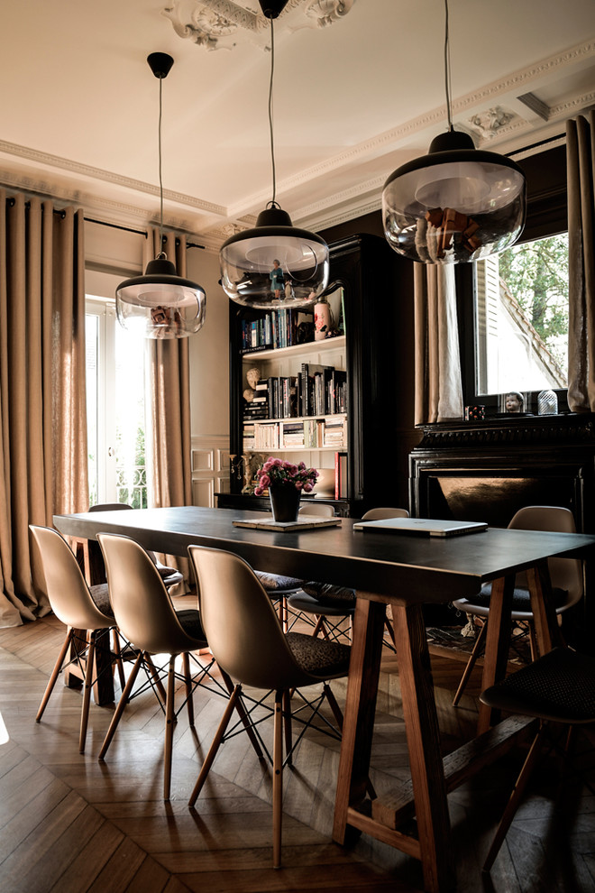 Idee per una sala da pranzo aperta verso il soggiorno design di medie dimensioni con parquet scuro, camino classico e pareti nere