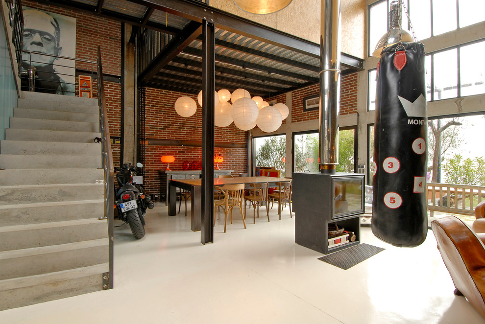 Idee per una grande sala da pranzo aperta verso il soggiorno industriale con pareti rosse