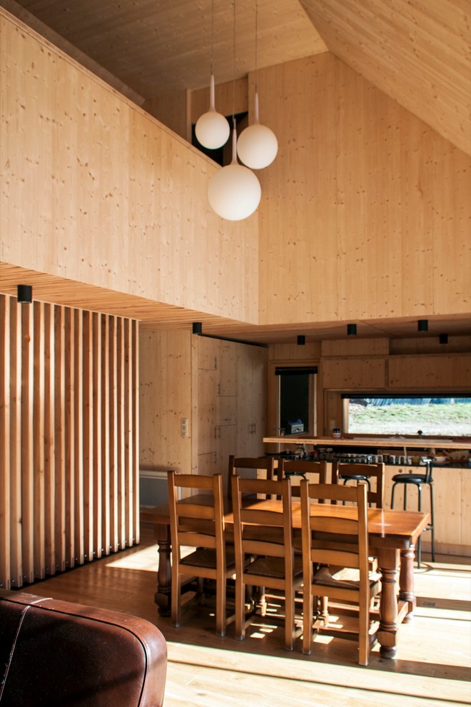 Cette photo montre une salle à manger ouverte sur le salon tendance de taille moyenne avec un mur marron.