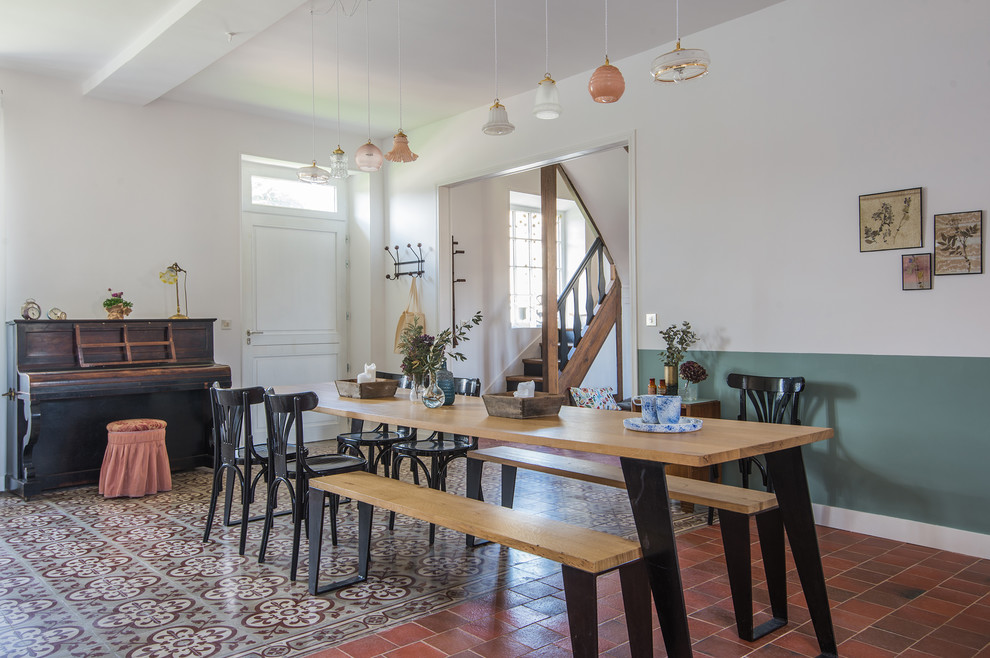 Inspiration for a country dining room in Paris with white walls and red floors.