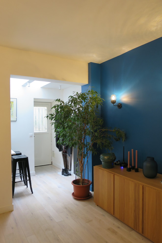Foto di una sala da pranzo aperta verso la cucina design di medie dimensioni con pareti blu, parquet chiaro, camino ad angolo, cornice del camino in mattoni e pavimento beige