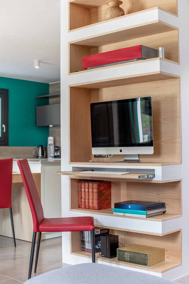 Inspiration för ett mellanstort funkis arbetsrum, med ett bibliotek, gröna väggar, klinkergolv i keramik, en dubbelsidig öppen spis, en spiselkrans i sten, ett inbyggt skrivbord och beiget golv