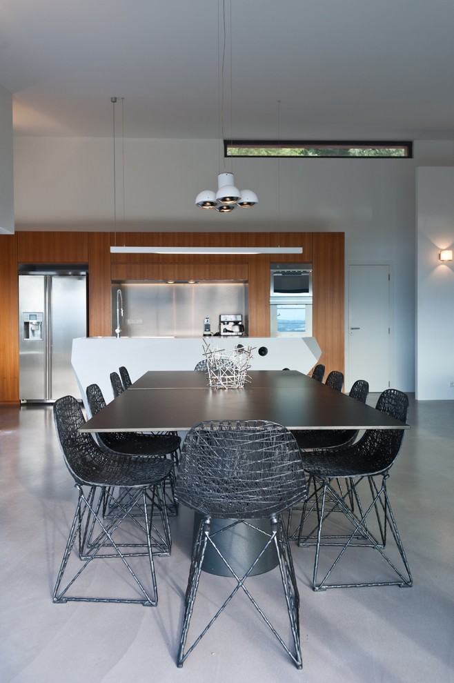 Large contemporary open plan dining room in Corsica with white walls, concrete flooring and no fireplace.