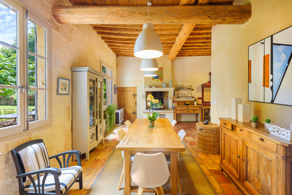 Réalisation d'une salle à manger ouverte sur le salon méditerranéenne de taille moyenne avec un mur beige, une cheminée standard et un manteau de cheminée en plâtre.