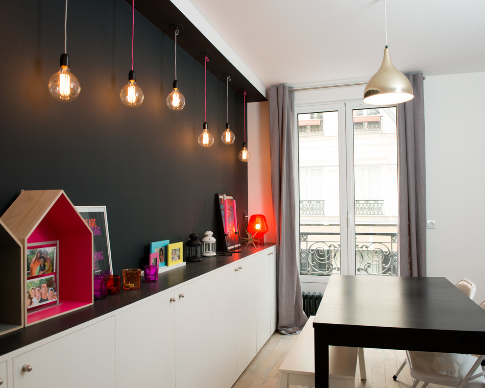 Mittelgroßes Skandinavisches Esszimmer ohne Kamin mit schwarzer Wandfarbe, hellem Holzboden und braunem Boden in Paris