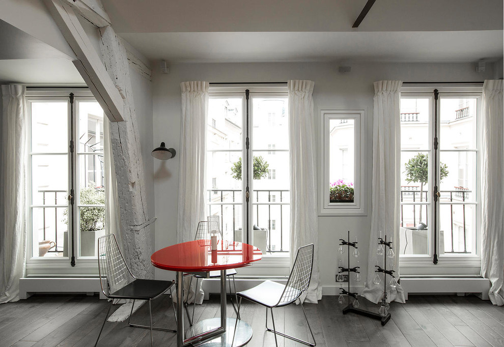 Cette image montre une grande salle à manger ouverte sur le salon design avec un mur blanc et un sol en bois brun.