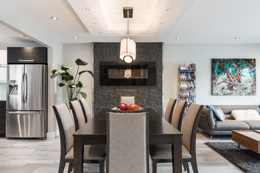 Стильный дизайн: кухня-столовая среднего размера в современном стиле с белыми стенами, полом из керамической плитки, стандартным камином, фасадом камина из камня и серым полом - последний тренд