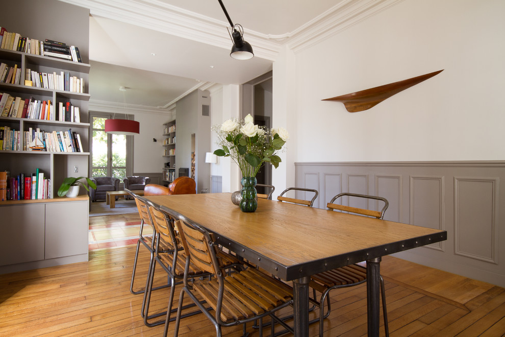 Inspiration pour une salle à manger ouverte sur le salon traditionnelle de taille moyenne avec un mur blanc, un sol en bois brun et éclairage.