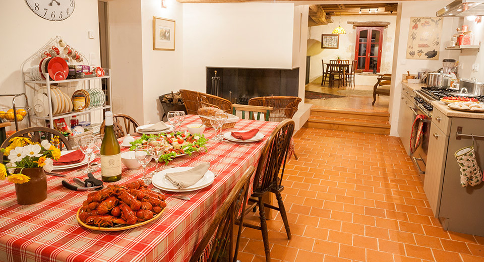 Exemple d'une salle à manger ouverte sur la cuisine nature de taille moyenne avec tomettes au sol et un mur blanc.