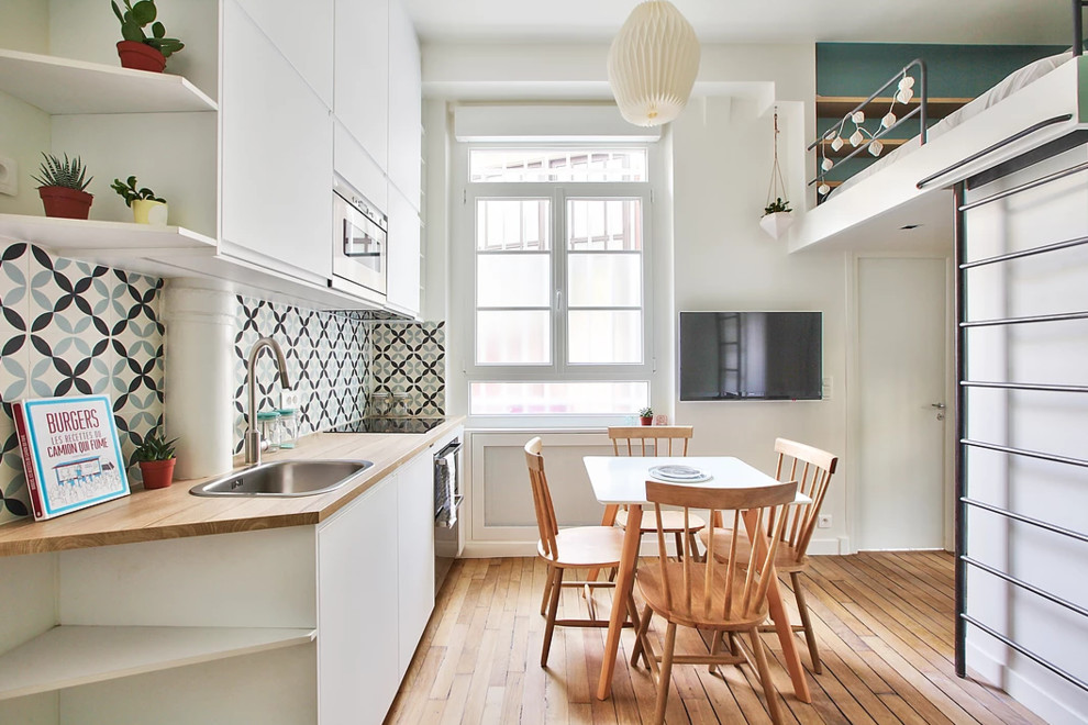 Cette photo montre une petite salle à manger ouverte sur le salon scandinave avec un mur blanc, un sol en bois brun et un sol marron.