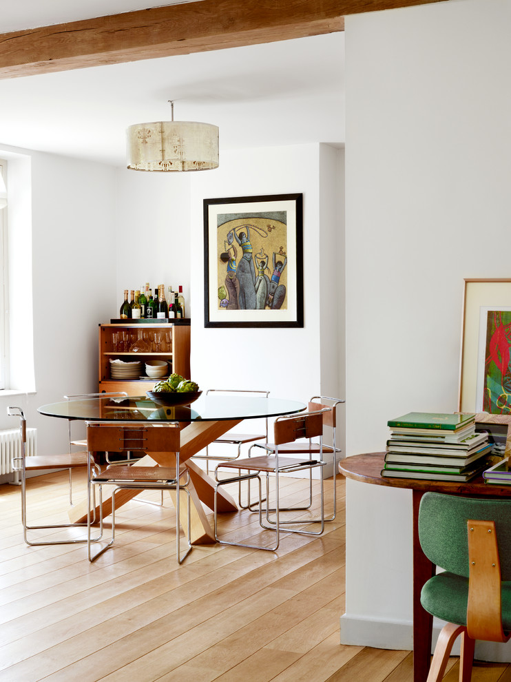 Diseño de comedor vintage con paredes blancas y suelo de madera en tonos medios
