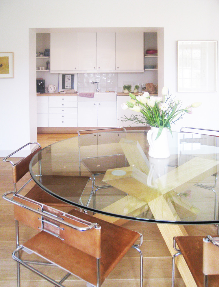 Источник вдохновения для домашнего уюта: столовая в стиле ретро с белыми стенами и паркетным полом среднего тона