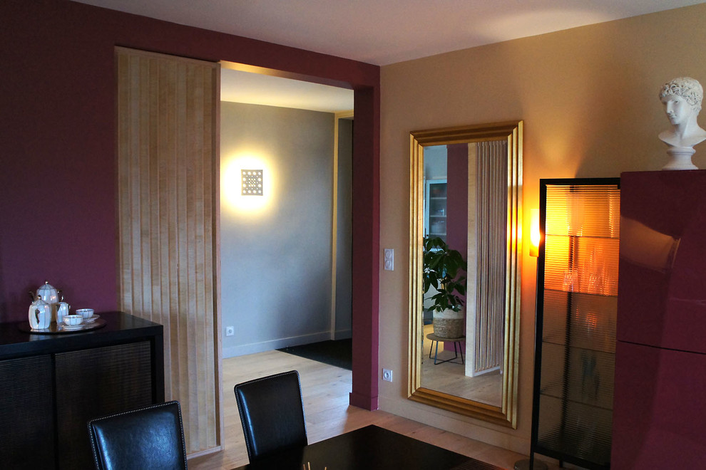 Modernes Esszimmer mit roter Wandfarbe, hellem Holzboden und beigem Boden in Angers