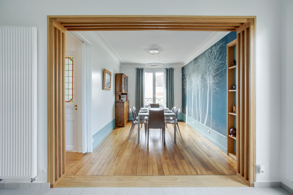 Diseño de comedor contemporáneo grande abierto sin chimenea con paredes verdes, suelo de madera clara y suelo beige