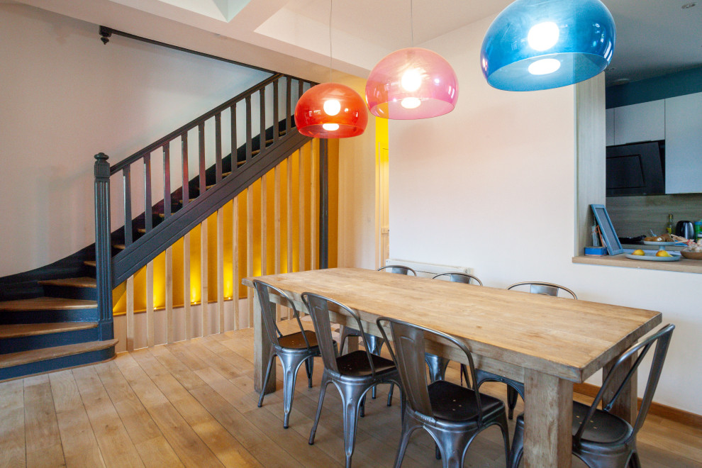 Esempio di una sala da pranzo contemporanea con pareti gialle, parquet chiaro e pavimento beige