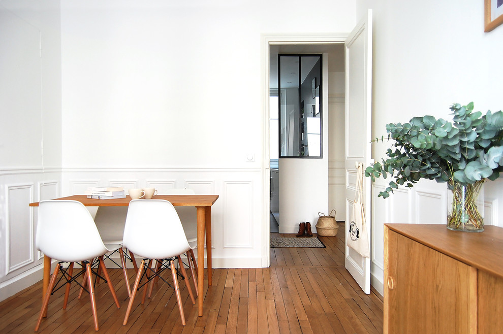 Immagine di una piccola sala da pranzo scandinava chiusa con pareti bianche, pavimento in legno massello medio, nessun camino e pavimento marrone