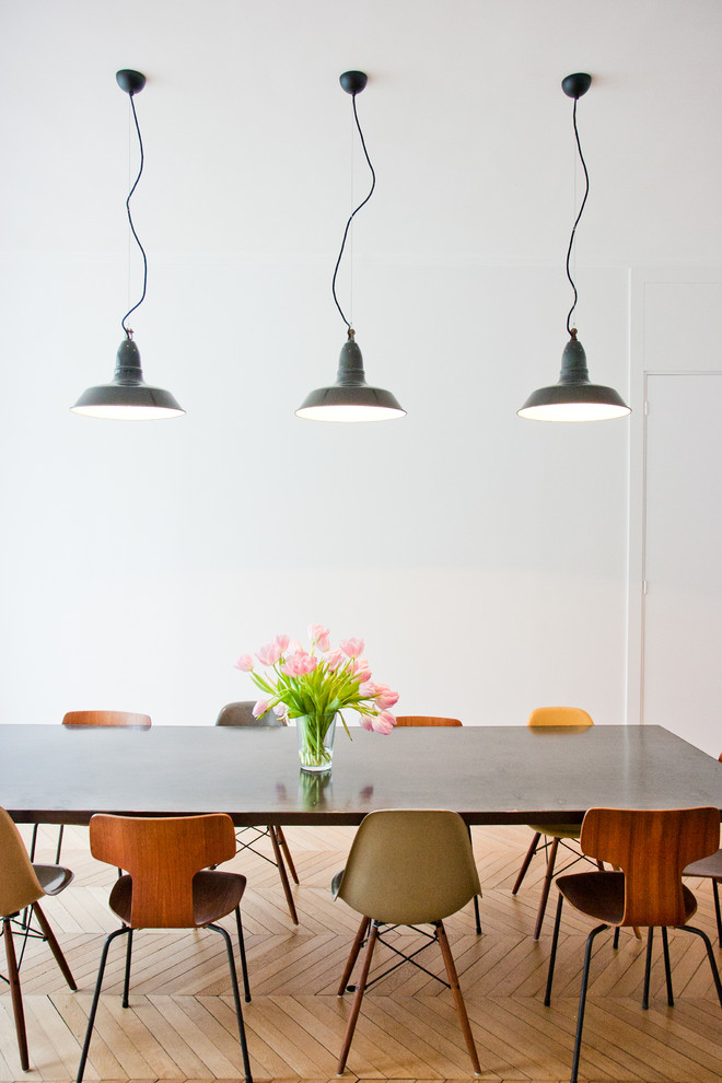 Réalisation d'une grande salle à manger design fermée avec un mur blanc, un sol en bois brun et aucune cheminée.