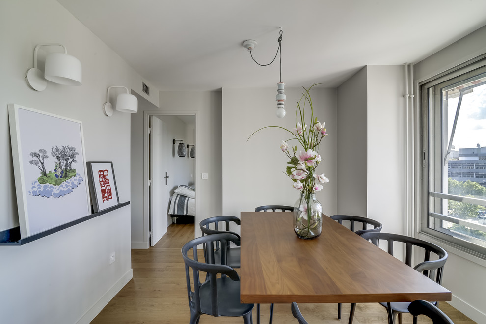 Cette image montre une petite salle à manger ouverte sur le salon design avec un mur beige, parquet clair et aucune cheminée.
