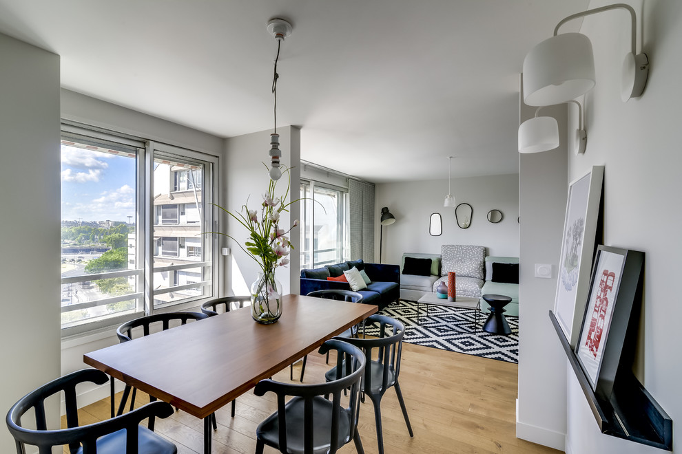 Design ideas for a contemporary open plan dining room in Paris with beige walls, light hardwood flooring and no fireplace.