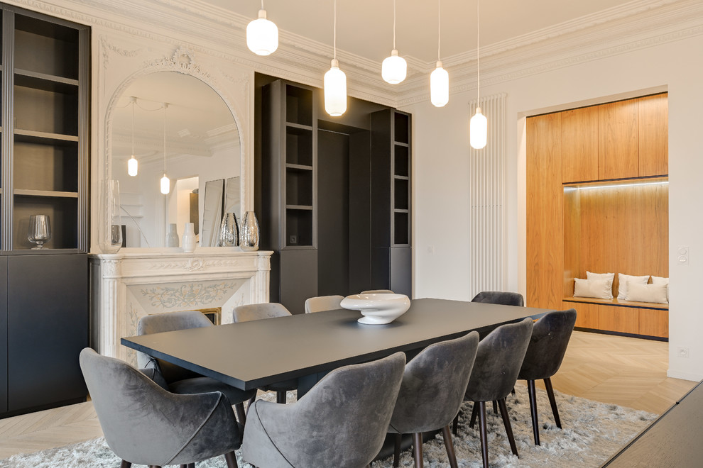 Idee per una grande sala da pranzo scandinava chiusa con pareti bianche, parquet chiaro e camino classico
