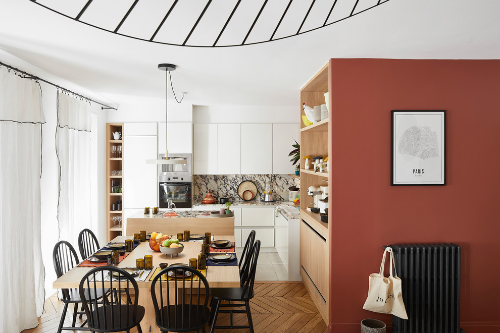 Offenes Skandinavisches Esszimmer mit roter Wandfarbe, braunem Holzboden und braunem Boden in Paris