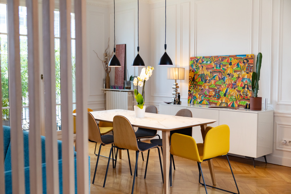 Cette image montre une salle à manger ouverte sur le salon design de taille moyenne avec un mur blanc, un sol en bois brun et un sol marron.