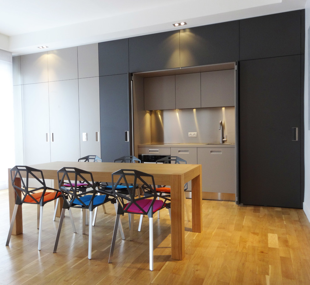 Medium sized contemporary open plan dining room in Paris with grey walls and medium hardwood flooring.