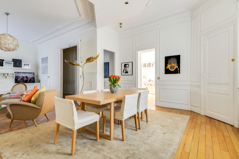 Idée de décoration pour une grande salle à manger ouverte sur le salon design avec un mur blanc, parquet clair, une cheminée d'angle, un manteau de cheminée en bois et un sol beige.