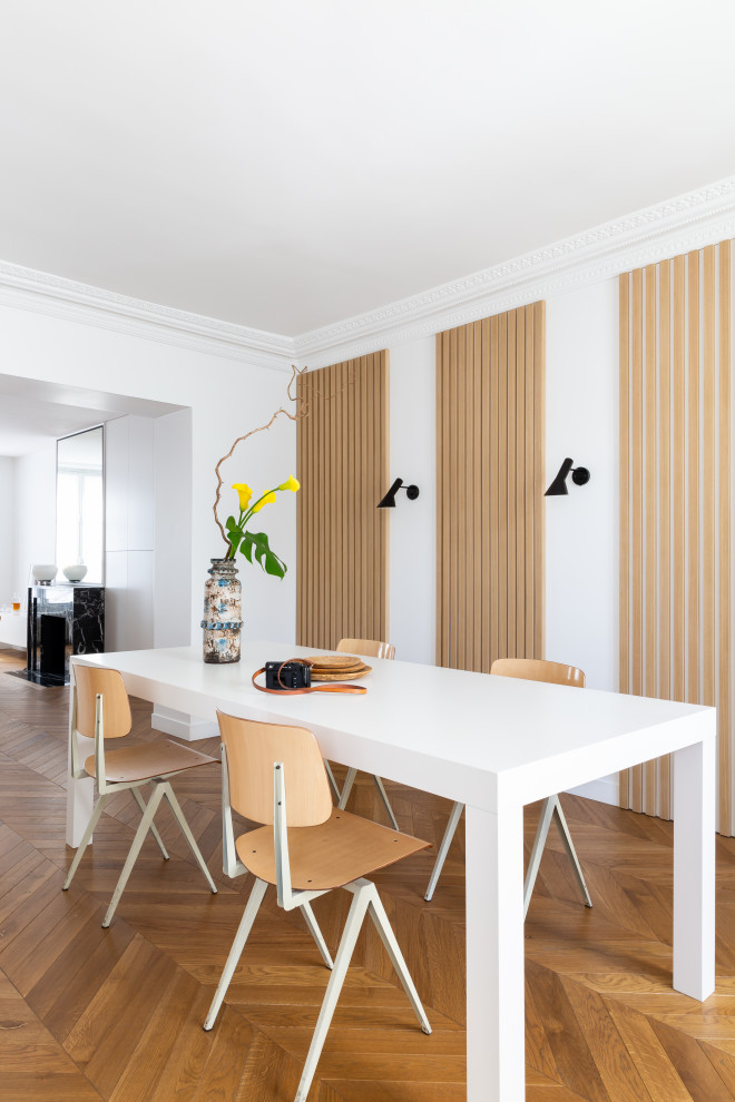 Design ideas for a scandi dining room in Paris with white walls, light hardwood flooring and brown floors.
