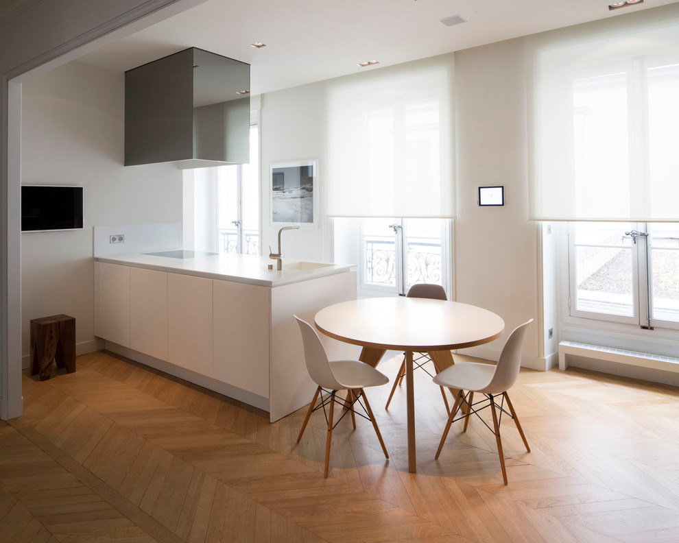 Idée de décoration pour une petite salle à manger ouverte sur le salon design avec un mur blanc et un sol en bois brun.