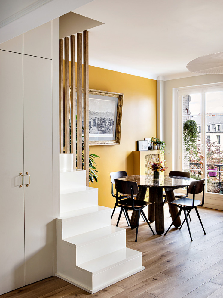 Идея дизайна: гостиная-столовая среднего размера в современном стиле с желтыми стенами и светлым паркетным полом