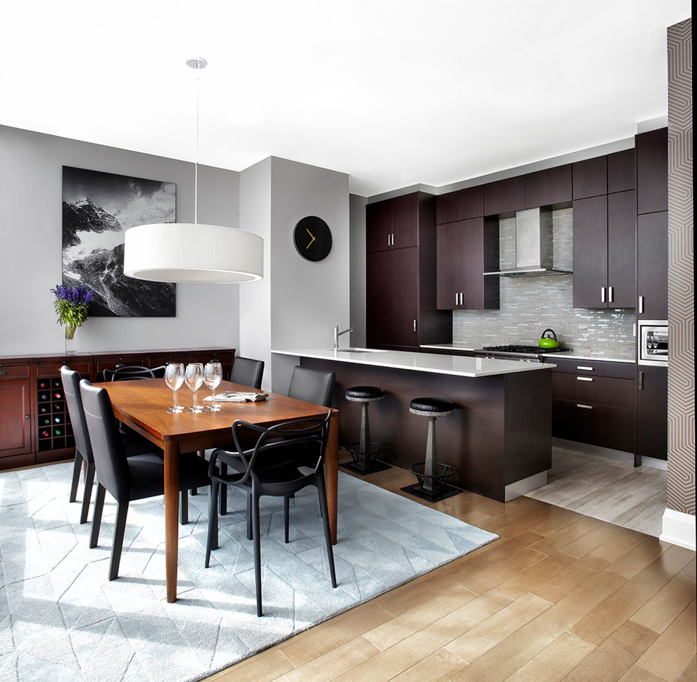 Exemple d'une salle à manger ouverte sur la cuisine tendance de taille moyenne avec un mur gris et un sol en bois brun.