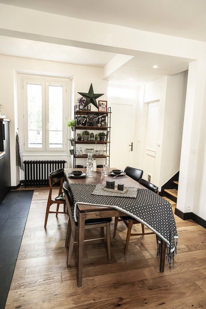Idée de décoration pour une salle à manger ouverte sur le salon vintage avec un mur blanc et parquet clair.