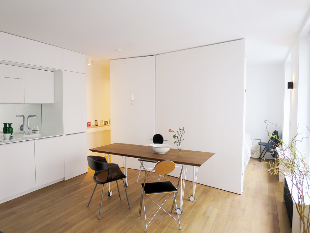 Exemple d'une petite salle à manger ouverte sur la cuisine scandinave avec un mur blanc.