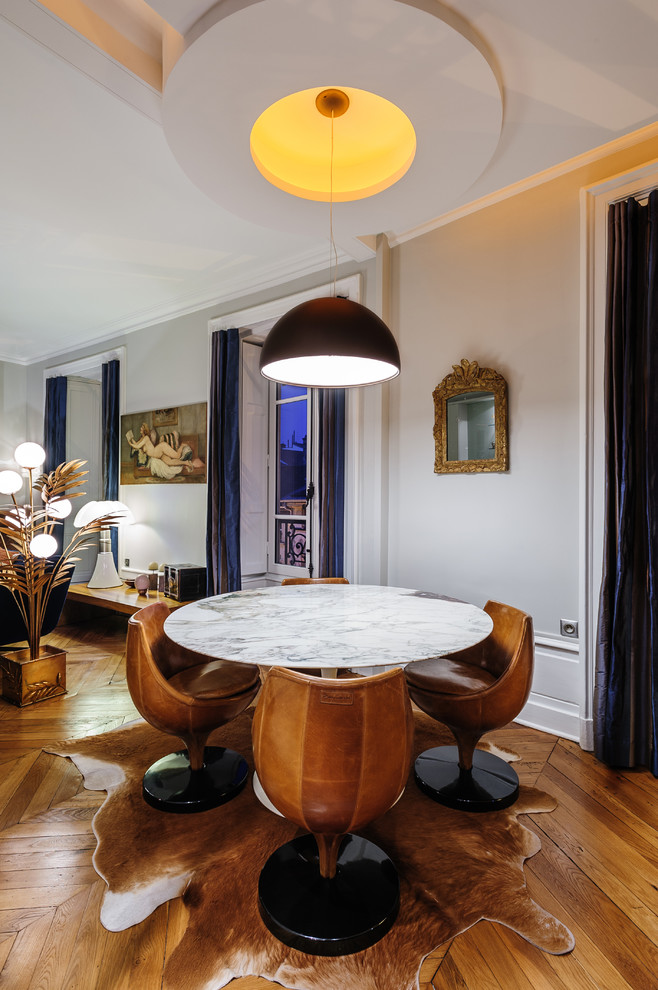 Idée de décoration pour une salle à manger ouverte sur le salon bohème de taille moyenne avec un mur gris, un sol en bois brun et aucune cheminée.