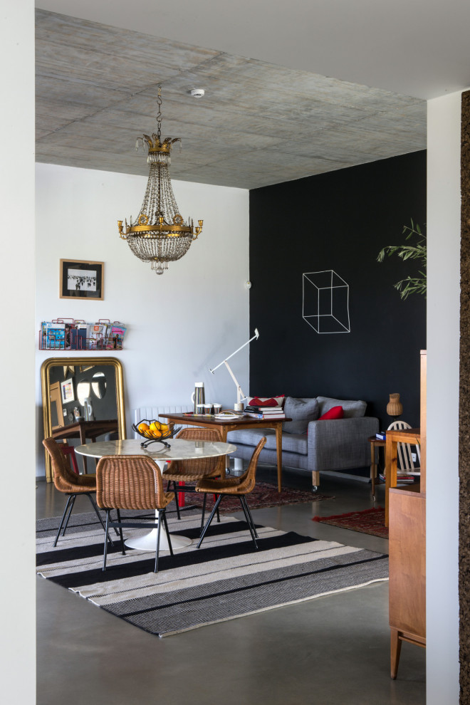 Aménagement d'une salle à manger ouverte sur le salon éclectique de taille moyenne avec un mur noir et un sol gris.