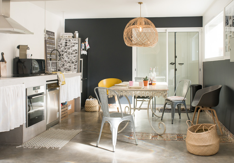 Idées déco pour une salle à manger ouverte sur la cuisine éclectique avec un mur noir, sol en béton ciré et un sol gris.