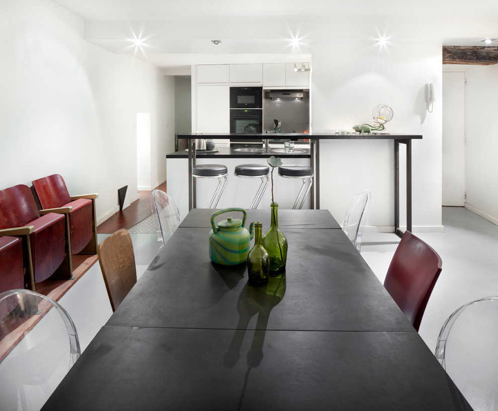 Cette photo montre une salle à manger ouverte sur la cuisine tendance de taille moyenne avec un mur blanc et aucune cheminée.